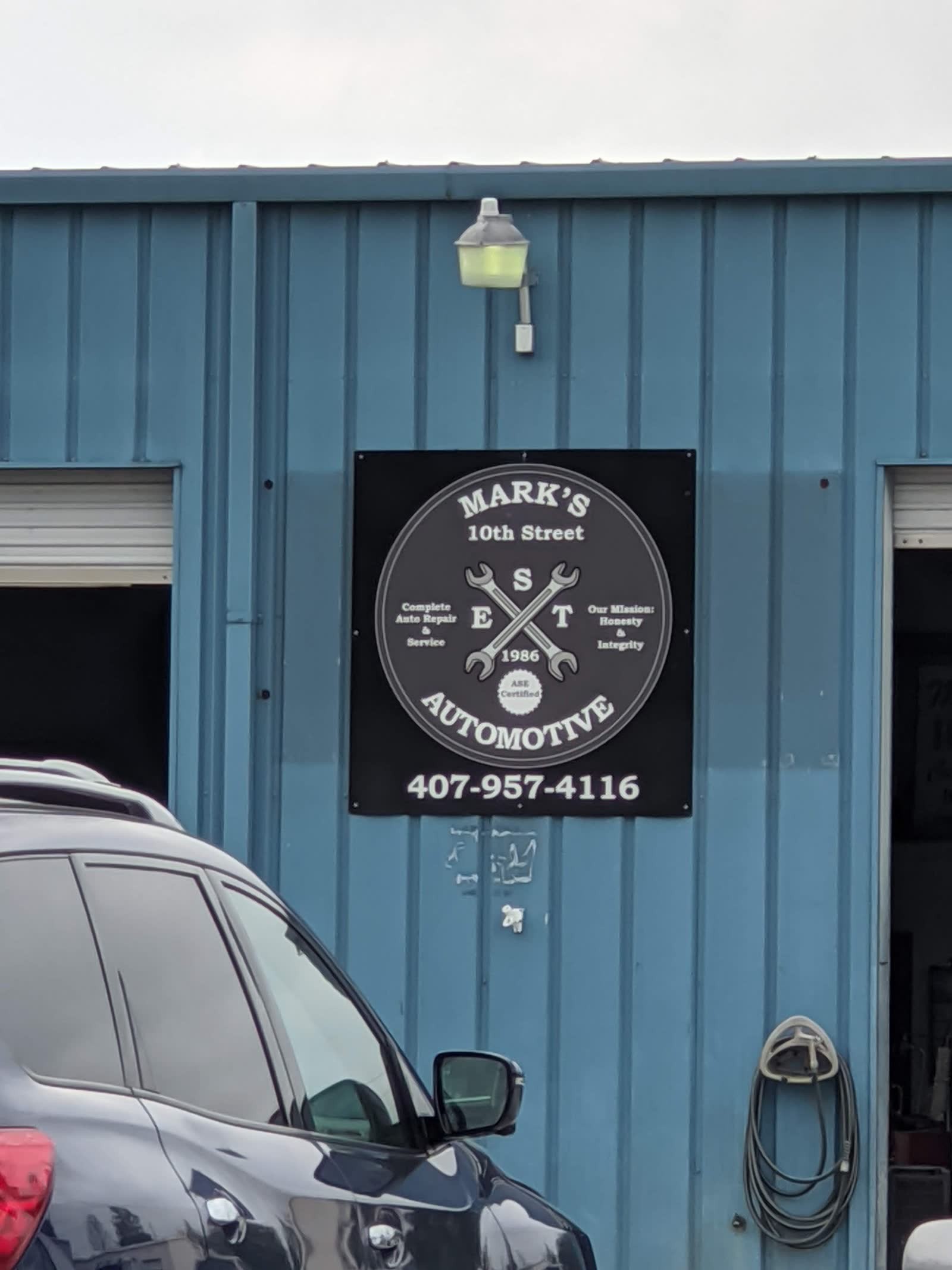 Circular Mark’s 10th Street Automotive sign, EST 1986, ASE certified, phone 407-957-4116
