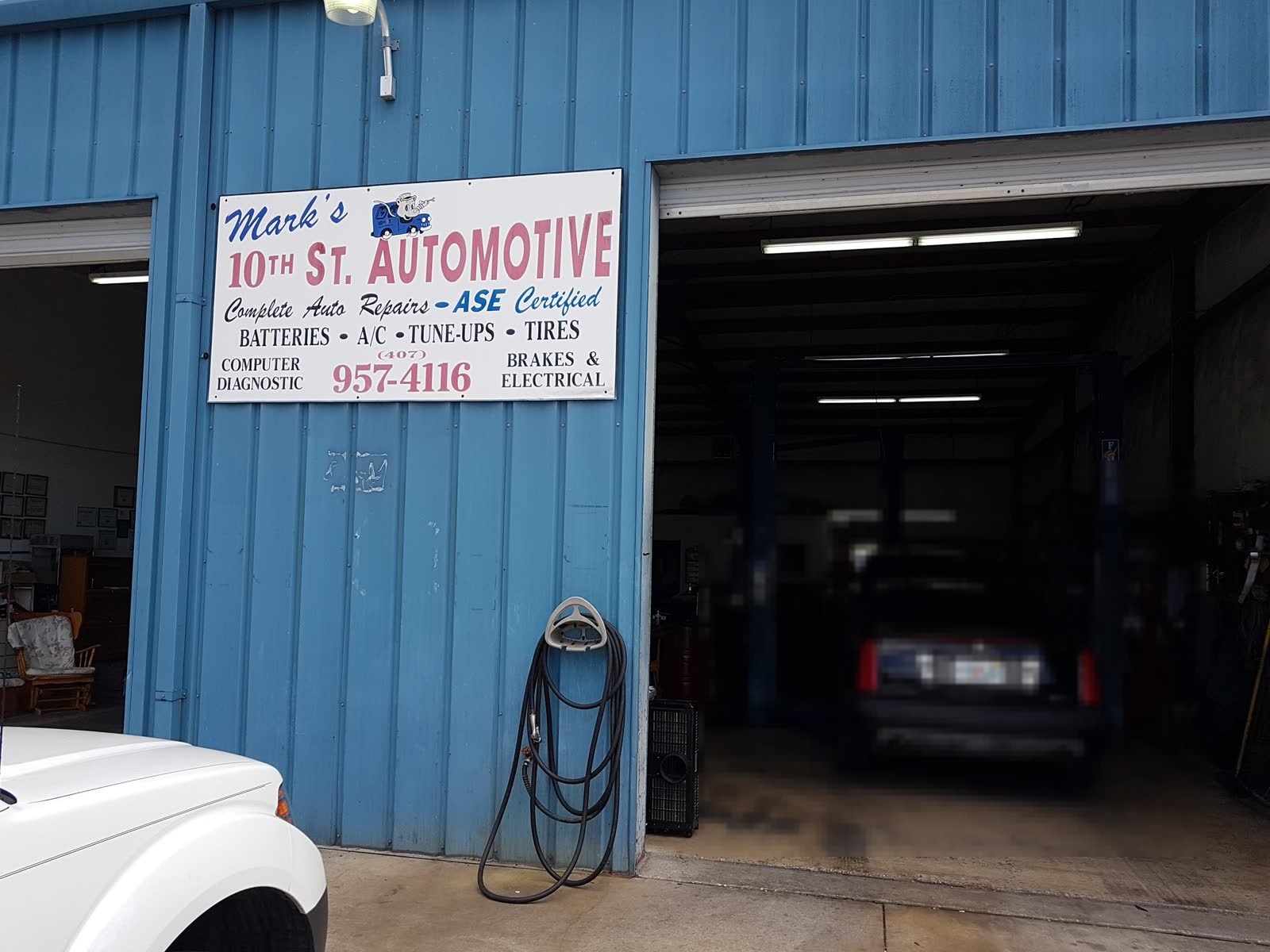 Open bay and shop sign on the blue metal building